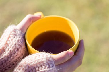Bir fincan çayı elinde tutan kadın.