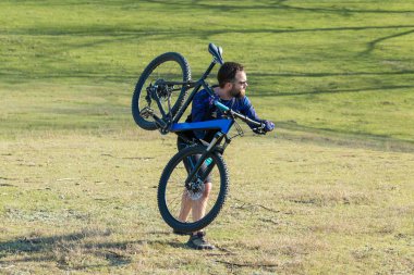 Parkta bisiklete binen genç adam 