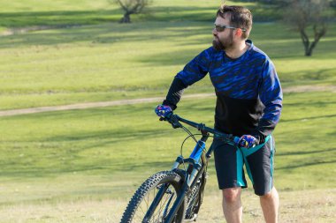 Parkta bisiklete binen genç adam 