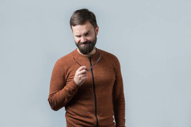 thoughtful young bearded caucasian man with glasses on white background