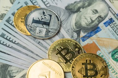 Şifreli altın sikkeler - Bitcoin, Ethereum, Litecoin 100 dolarlık banknotun arka planına karşı. Sanal para kavramı.