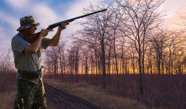 Male hunter with shotgun hunting outdoors