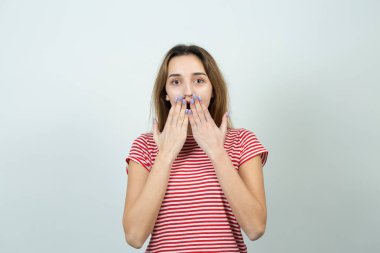 Young surprised caucasian girl covering open mouth on white background