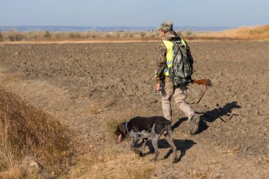 Male hunter with shotgun hunting outdoors