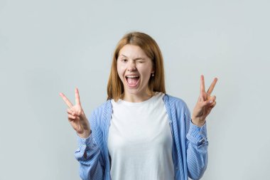 Gri bir arka plan üzerinde kızıl saçlı bir kızın duygusal portresi, fırtınalı duygular, iş kavramı.