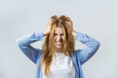 Gri bir arka plan üzerinde kızıl saçlı bir kızın duygusal portresi, fırtınalı duygular, iş kavramı.