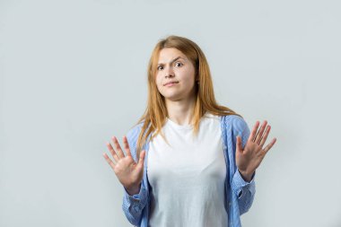 Gri bir arka plan üzerinde kızıl saçlı bir kızın duygusal portresi, fırtınalı duygular, iş kavramı.