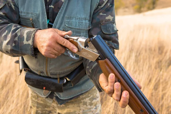 狩猟期間 秋のシーズンを開いています 秋の森の中でトロフィーを求めて狩猟用の服を手に銃を持ったハンター — ストック写真