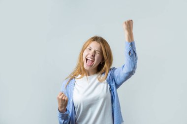 Gri bir arka plan üzerinde kızıl saçlı bir kızın duygusal portresi, fırtınalı duygular, iş kavramı.