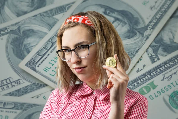 ドルで背景に対して彼女の手に物理的なビットコイン暗号通貨を保持している女性 — ストック写真