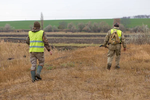 猎人带着枪和狗在草原的寒冷秋天 狩猎野鸡在反光背心 — 图库照片