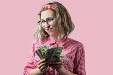 Elinde Amerikan doları para ile gözlük kırmızı ekose gömlek genç güzel kadın Closeup