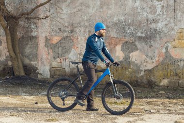 Şort ve mayo modern bir karbon hardtail bisiklet üzerinde bir hava süspansiyon çatal sürmek off-road turuncu-kırmızı tepelerde yaz aylarında gün batımı akşamı