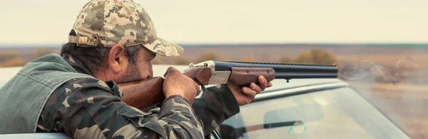 Hunter with a gun and a dog go on the first snow in the steppe, Hunting pheasant in a reflective vest