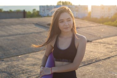 Güzel ince atletik kız egzersizleri açık havada bir dizi gerçekleştirir. Yoga yapmaktan özgürlük duygusu.