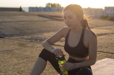 Güzel ince atletik kız egzersizleri açık havada bir dizi gerçekleştirir. Yoga yapmaktan özgürlük duygusu.