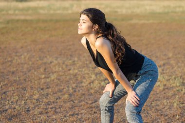 Güzel ince atletik kız egzersizleri açık havada bir dizi gerçekleştirir. Yoga yapmaktan özgürlük duygusu.