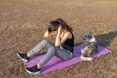 Güzel ince atletik kız egzersizleri açık havada bir dizi gerçekleştirir. Yoga yapmaktan özgürlük duygusu.