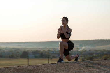 Güzel ince atletik kız egzersizleri açık havada bir dizi gerçekleştirir. Yoga yapmaktan özgürlük duygusu.