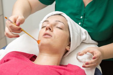 Kadın güzellik salonunda maske takıyor.