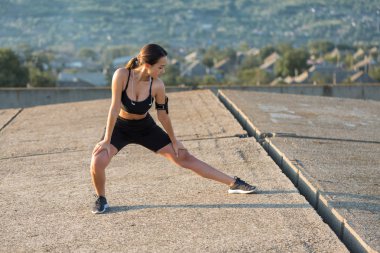 Güzel ince atletik kız egzersizleri açık havada bir dizi gerçekleştirir. Yoga yapmaktan özgürlük duygusu.