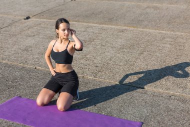 Güzel ince atletik kız egzersizleri açık havada bir dizi gerçekleştirir. Yoga yapmaktan özgürlük duygusu.