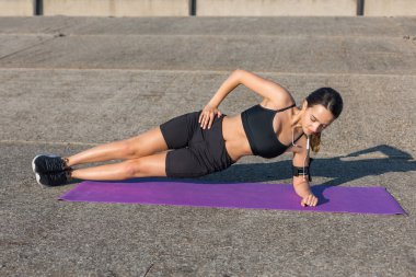 Güzel ince atletik kız egzersizleri açık havada bir dizi gerçekleştirir. Yoga yapmaktan özgürlük duygusu.