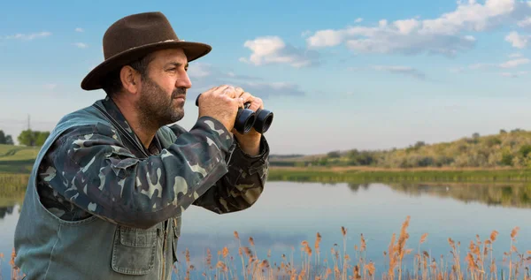 Ein Jäger Mit Hut Und Fernglas Sucht Vor Dem Hintergrund — Stockfoto