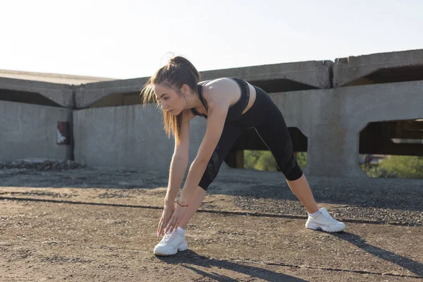 Slim Sportos Lány Végez Nyújtó Gyakorlatok Tetőn Egy Befejezetlen Épület — Stock Fotó