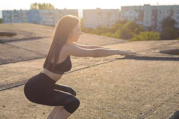 Spor giyimli, yılan derisi baskılı genç ve zayıf bir atletik kız bir takım egzersizler yapıyor. Fitness ve sağlıklı yaşam tarzı.