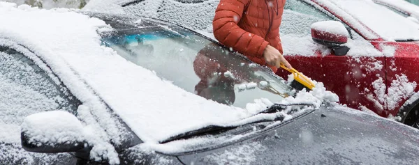Adam karları arabada yıkıyor.