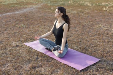 Spor giyimli, yılan derisi baskılı genç ve zayıf bir atletik kız bir takım egzersizler yapıyor. Fitness ve sağlıklı yaşam tarzı.