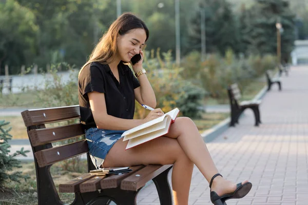 Uma Jovem Senta Banco Parque Faz Anotações Vestido Estilo Livre — Fotografia de Stock