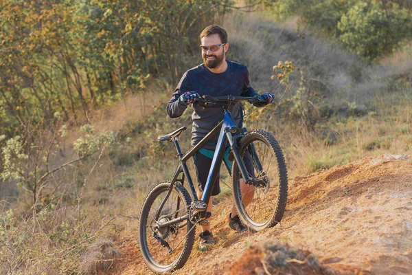 Conquering mountain peaks by cyclist in shorts and jersey on a modern carbon hardtail bike with an air suspension fork . Beautiful view from the mountain. Panoramic view for banner.