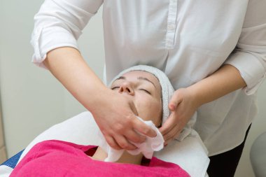 Spa salonunda yüz masajı yaptıran kadın.