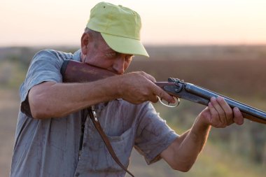 Av dönemi, sonbahar sezonu açıldı. Avcı elinde silahla sonbahar ormanında av elbisesi içinde ganimet arıyor..