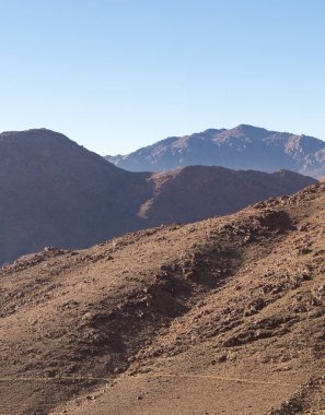 Gün doğumunda görünür sis ile siluet dağ sırası. Uçsuz bucaksız çölün güzel dağları.