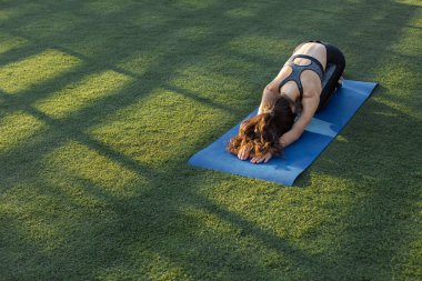 Yılan derisi baskılar ile spor genç ince atletik kız egzersizleri bir dizi gerçekleştirir.
