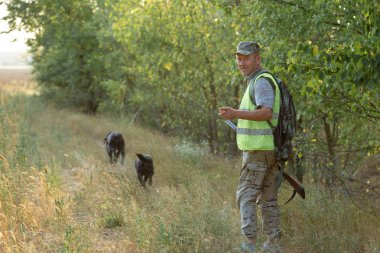 Av dönemi, sonbahar sezonu açıldı. Avcı elinde silahla sonbahar ormanında av elbisesi içinde ganimet arıyor..