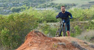 Şortlu ve formalı bisikletçilerle dağ zirvelerini hava askı çatalıyla modern bir karbon kuyruklu bisikletle fethetmek. Dağdan manzara çok güzel. Panoramik pankart görünümü.