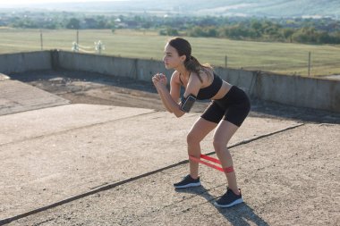 Spor giyimli genç, zayıf, atletik bir kız bir takım egzersizler yapıyor. Fitness ve sağlıklı yaşam tarzı. 
