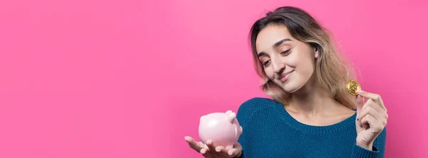 Girl Puts Piggy Bank Physical Bitcoin Young Girl Pink Background — Stock Photo, Image