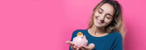 Girl Puts Piggy Bank Physical Bitcoin Young Girl Pink Background — Stock Photo, Image