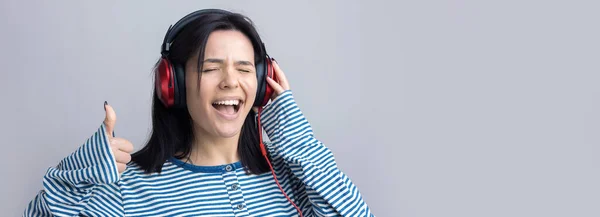 Una Giovane Ragazza Con Gilet Righe Sta Ascoltando Musica Cuffie — Foto Stock