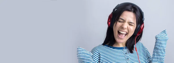 Una Joven Con Chaleco Rayas Está Escuchando Música Con Auriculares —  Fotos de Stock