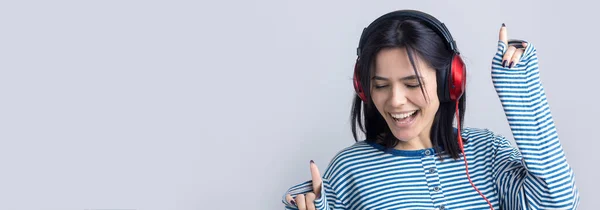 Una Joven Con Chaleco Rayas Está Escuchando Música Con Auriculares — Foto de Stock