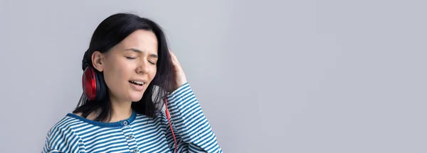 Una Joven Con Chaleco Rayas Está Escuchando Música Con Auriculares —  Fotos de Stock