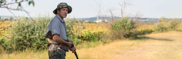 Σιλουέτα Ενός Κυνηγού Ένα Όπλο Στα Καλάμια Ενάντια Στον Ήλιο — Φωτογραφία Αρχείου
