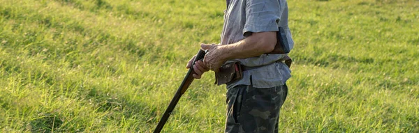 一个拿着枪在芦苇里对抗太阳的猎人的肖像 一个猎狗的鸭子的埋伏 — 图库照片