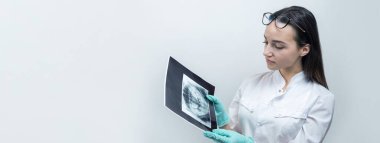 Beyaz önlüklü kız dişçi hastanın dişlerinin fotoğrafını tutuyor..